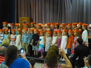Kindergarteners wearing caps on stage